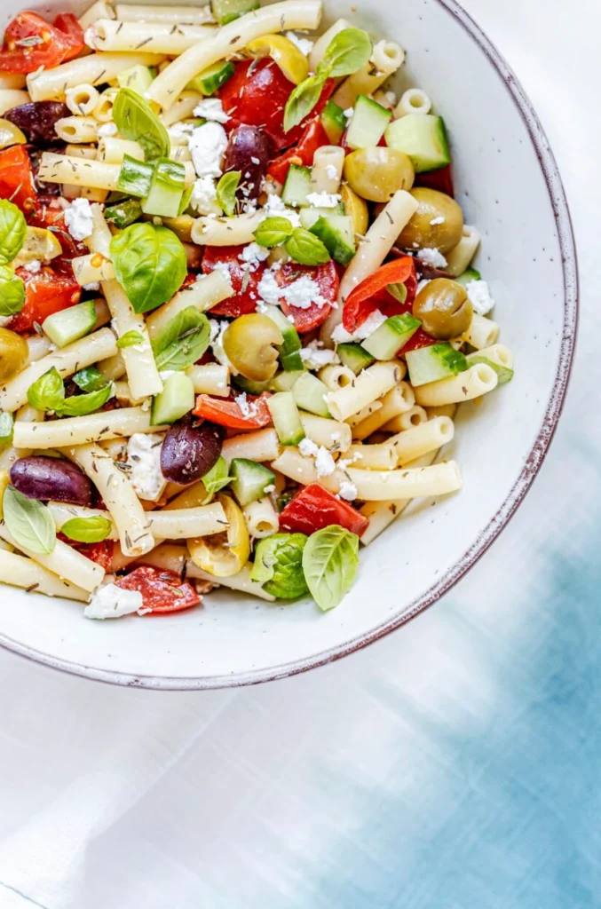 Macaroni pasta salad with feta and olives, healthy Greek summer dish
