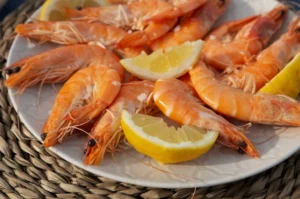 Perfectly baked shrimp with vibrant lemons on a plate.