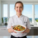 A vibrant, healthy quinoa salad full of vegetables, nuts, and a drizzle of dressing.